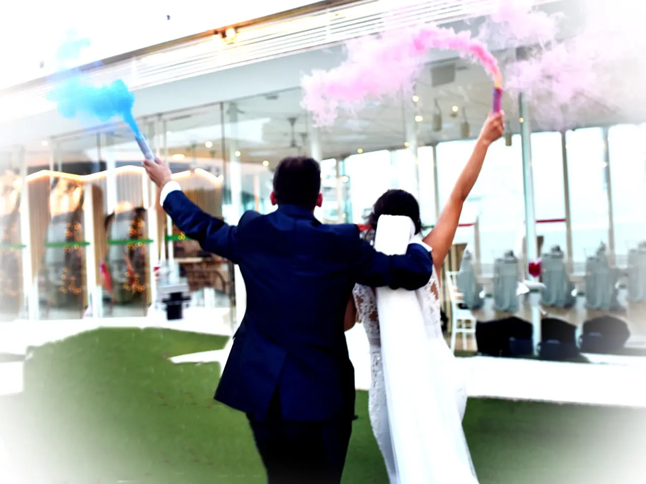 Pareja de novios con bengalas de humo de colores.