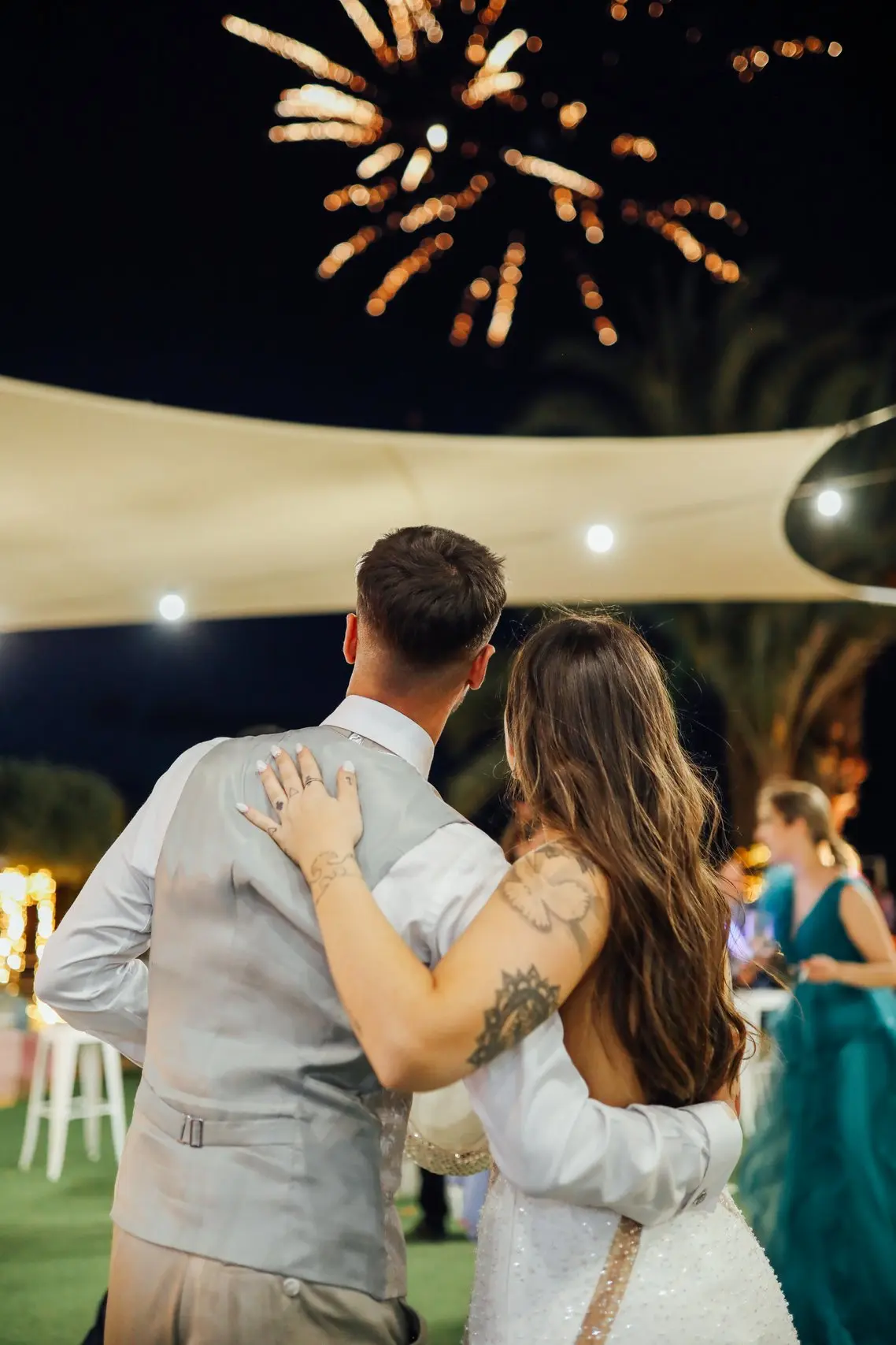 Pareja de novios disfrutando de espectáculo de fuegos artificiales durante la celebración de su boda en Finca el Jardín de la Estación